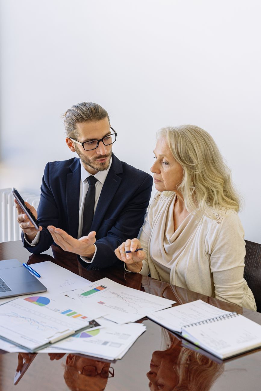A Plumbline adviser talking a client through her portfolio, planning charts on the table